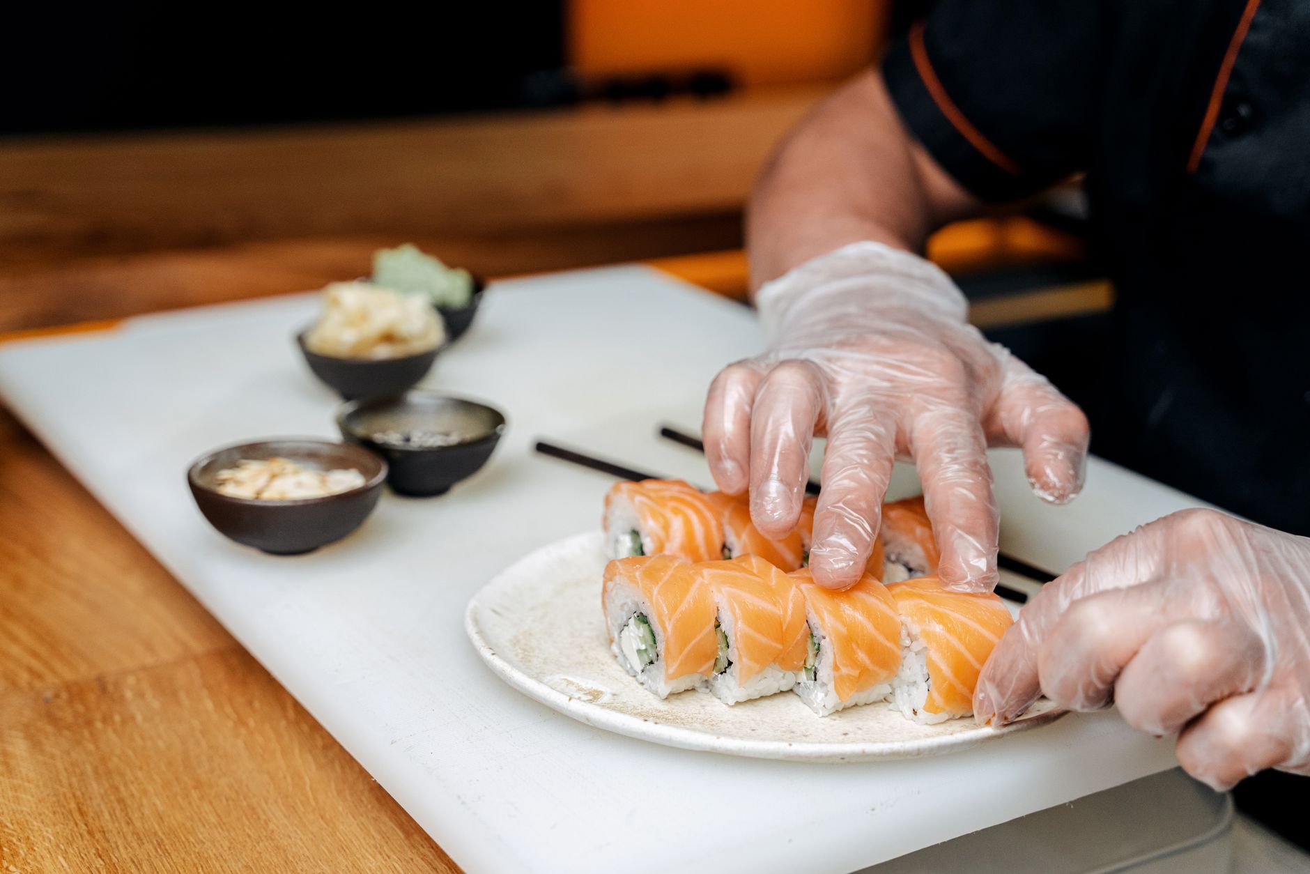Chef slicing fresh fish for sushi with sharp knife