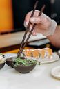 A Person Wearing Gloves Clamping Leaves with Chopsticks