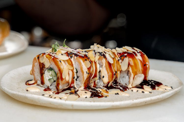 Sushi Roll With Garnish On White Ceramic Plate