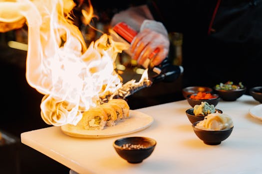 Chef using a blow torch to prepare sushi, showcasing culinary skills and Japanese cuisine.