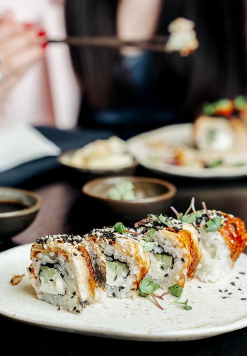 Free Close-up of assorted sushi rolls on a plate with soy sauce, indoors dining setting. Stock Photo
