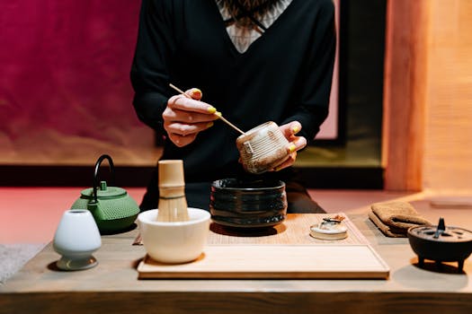 A serene traditional tea ceremony setup with a focus on bamboo whisk and pottery elements.
