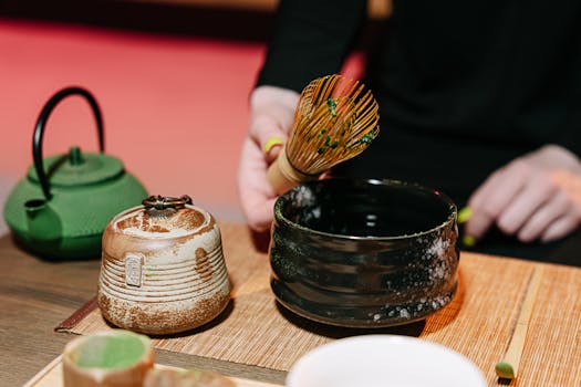 Experience the art of matcha tea preparation using traditional bamboo chasen and teapot.