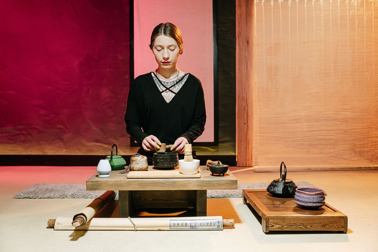 a serene japanese tea ceremony featuring a woman preparing tea with tr
