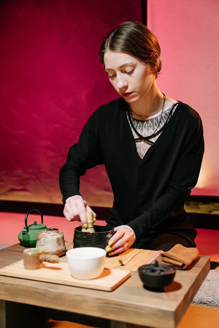 A Woman In Black Top Making Tea