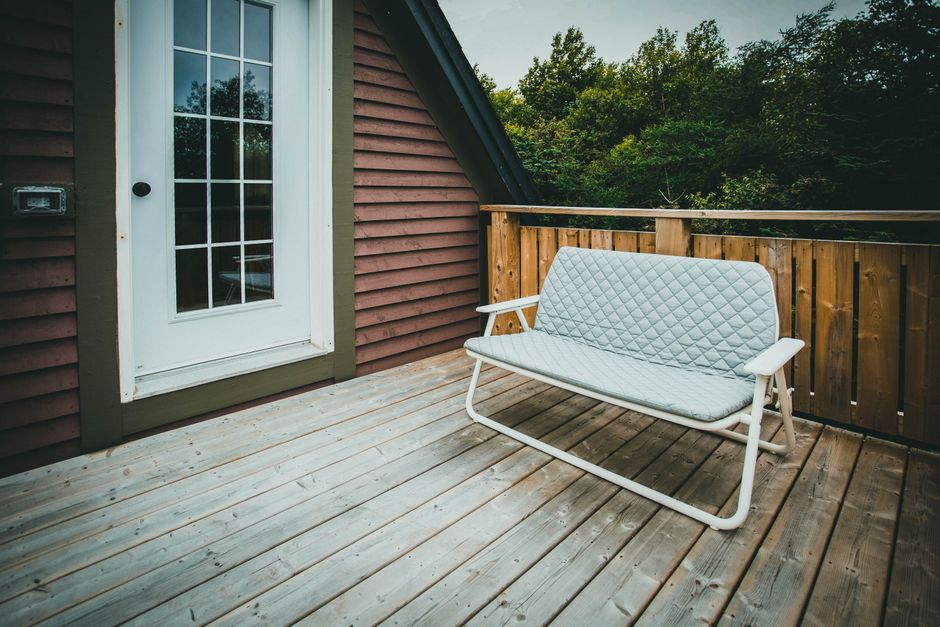 Kleiner Balkon mit hellen Klickfliesen, kompakter Sitzgruppe und ruhiger, wohnlicher Optik
