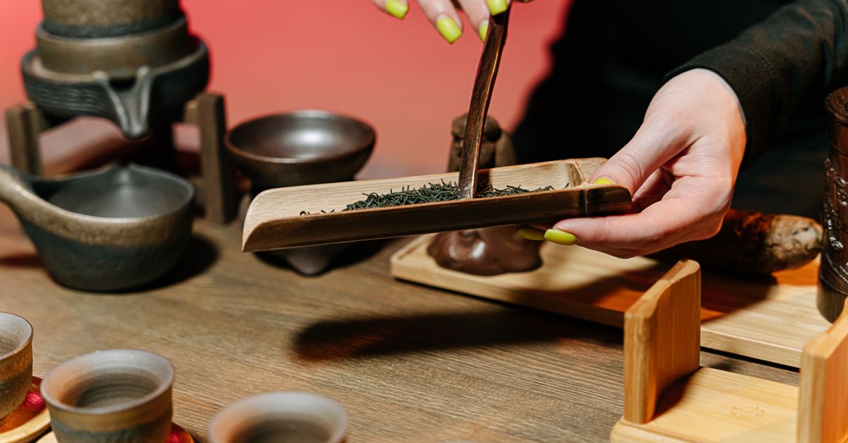 Close-up of a traditional tea ceremony using bamboo tools and teacups on a wooden table. - Evidence evidence guide for green tea attention randomized trial