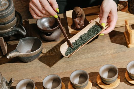 Close-up of a traditional tea ceremony with wooden tools and herbal tea leaves.