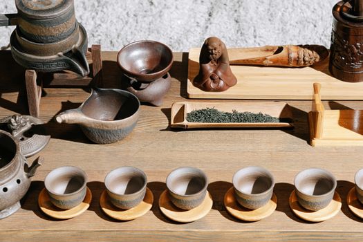 Close-up of a traditional tea ceremony setup with rustic teapots and cups, showcasing cultural heritage.