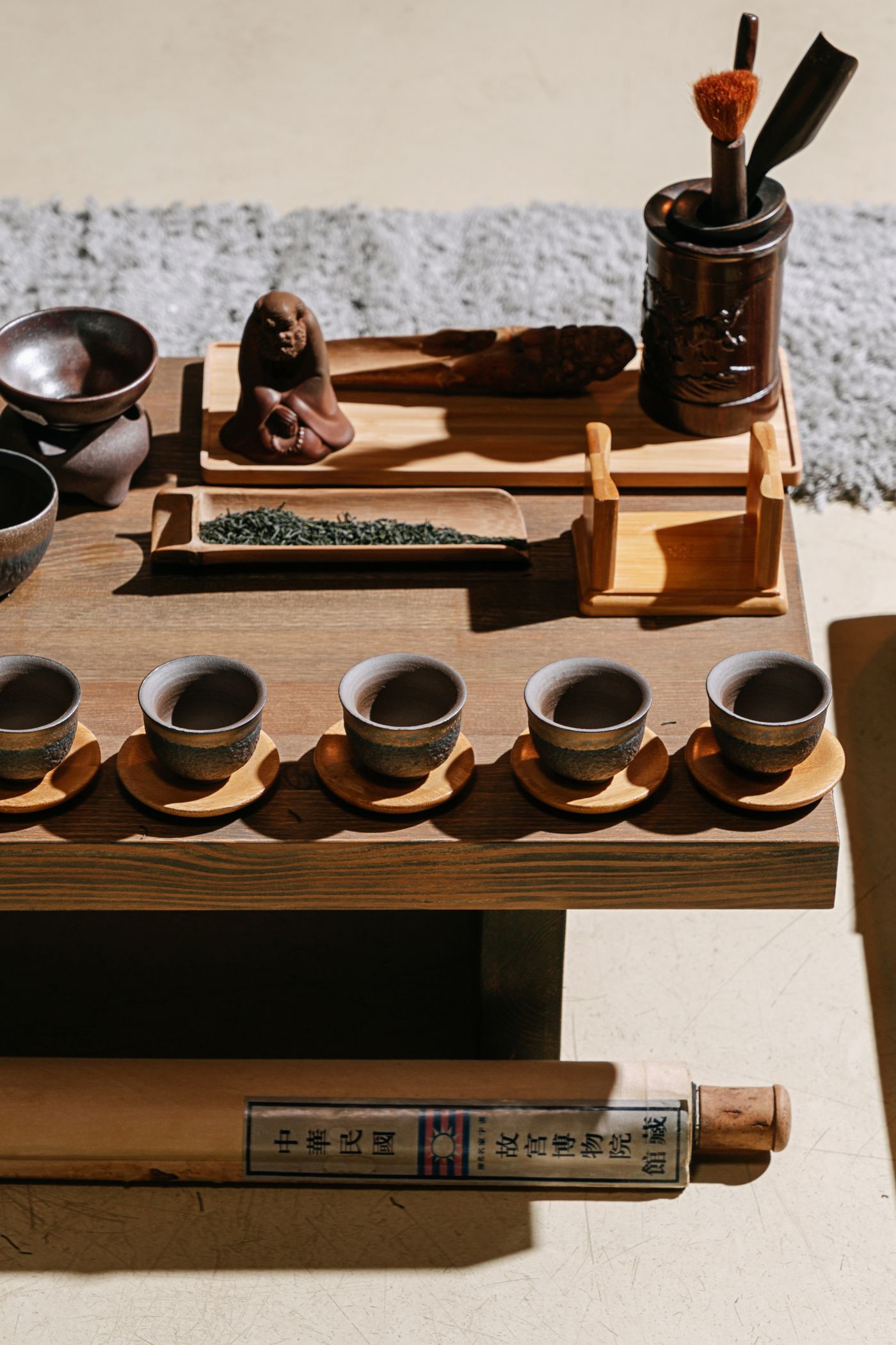 A traditional tea ceremony setup with cups and leaves.