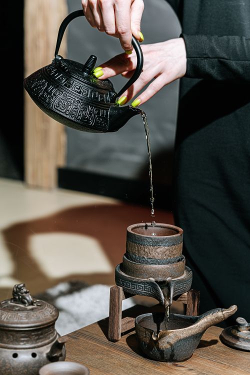 Free Close-up of a traditional tea ceremony pouring tea from an ornate teapot. Stock Photo