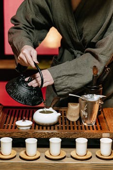 A serene traditional tea ceremony setup with tea being poured into cups.