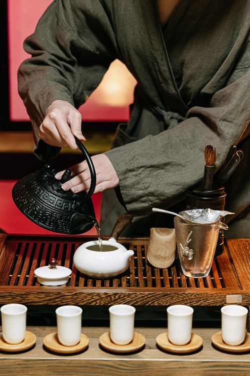 Free A serene traditional tea ceremony setup with tea being poured into cups. Stock Photo