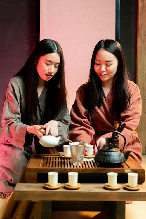 A Woman Pouring Tea in a Tea Cup