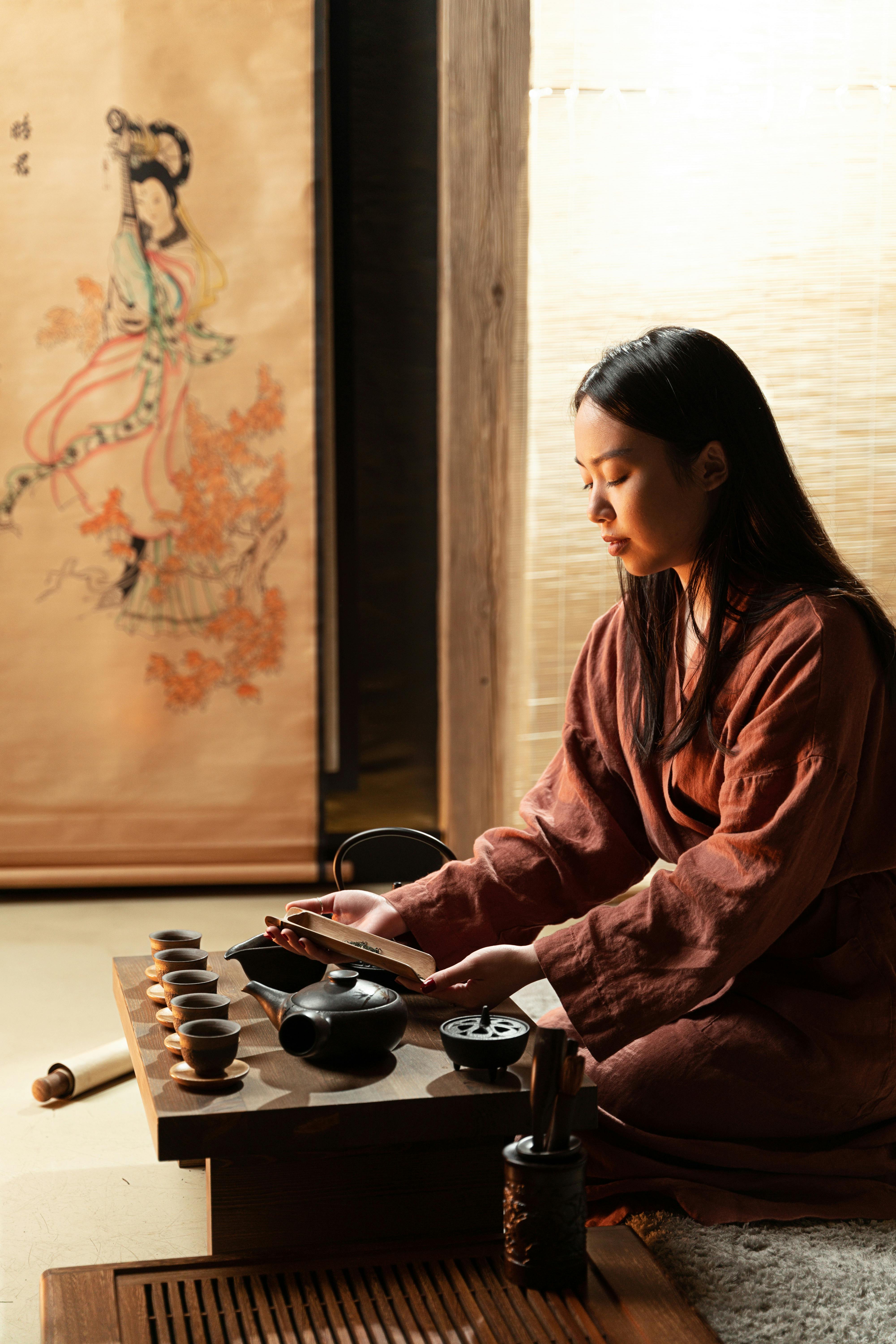 a woman in brown long sleeves preparing tea