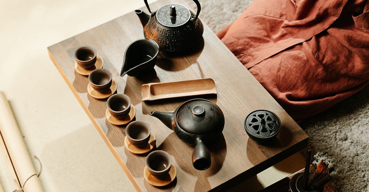 A serene setup of a traditional tea ceremony featuring rustic teapots and cups on a wooden table.