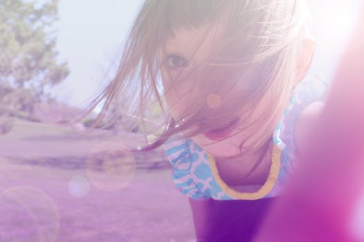 一个开朗的孩子在阳光明媚的夏日里户外玩耍，镜头带有耀斑效果