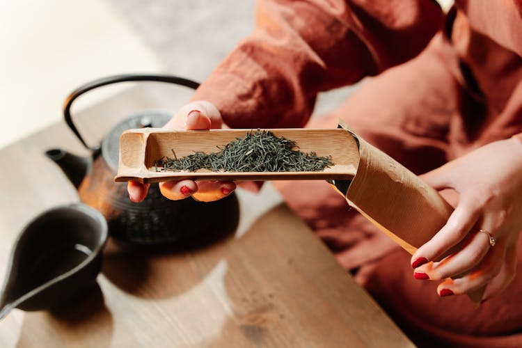 Person Putting Tea Leaves In A Pouch