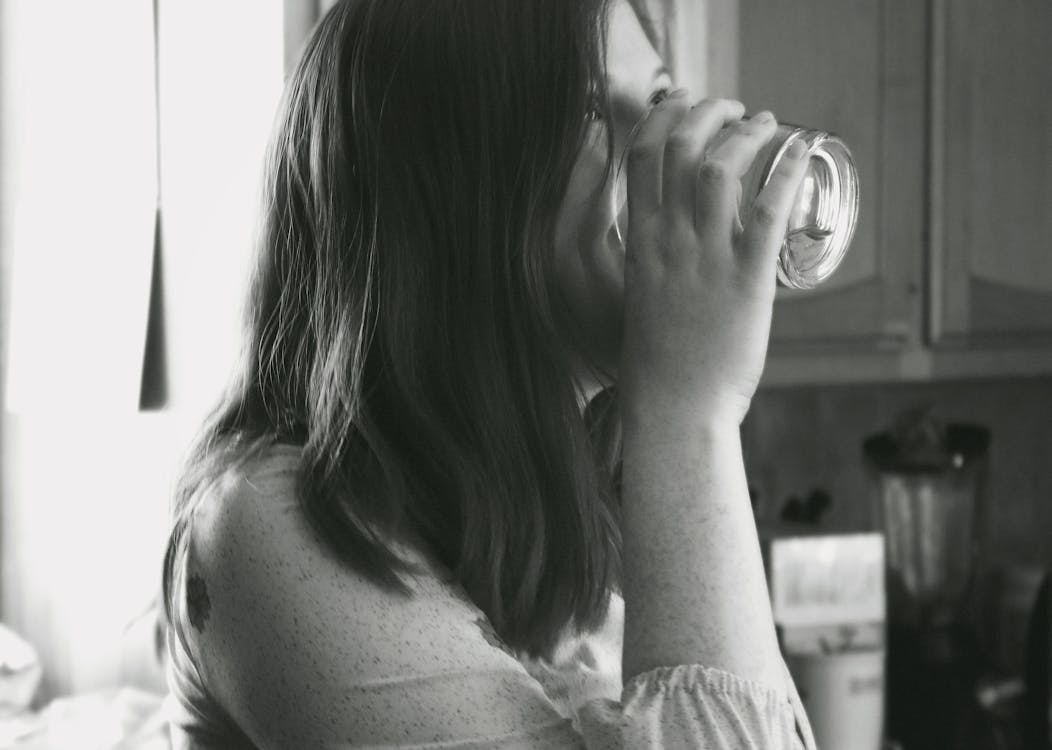 Bezpłatne Zdjęcie Lady Drinking Water W Skali Szarości Zdjęcie z galerii