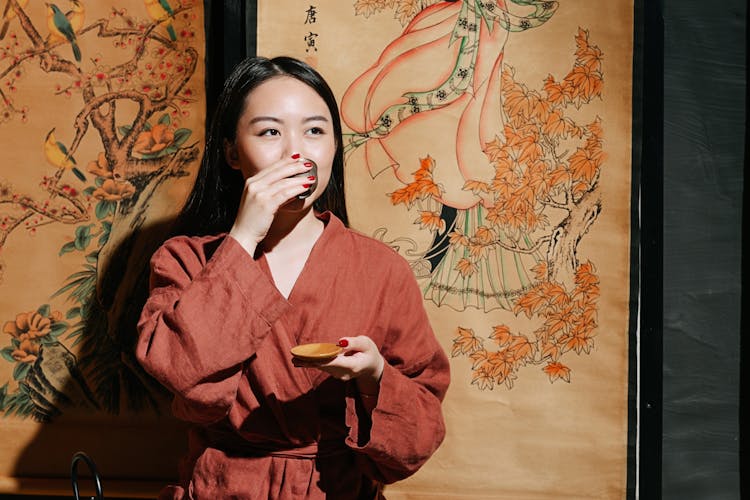 A Woman In Robe Drinking Tea