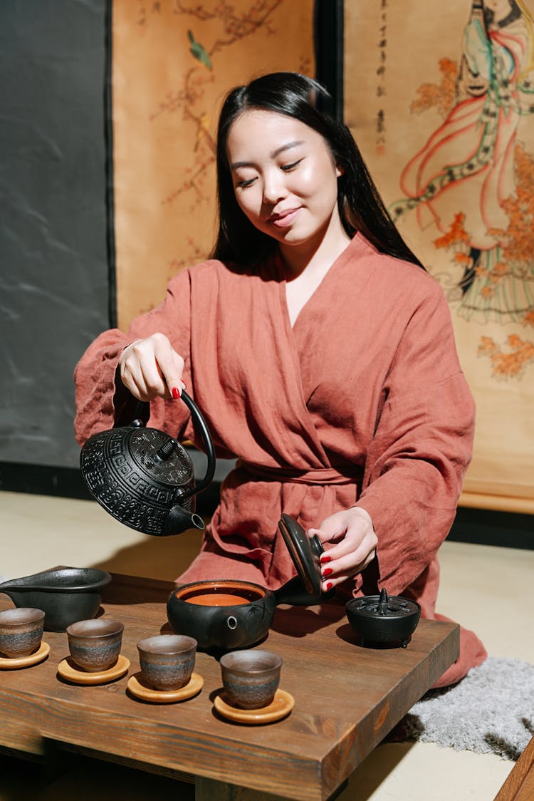 A Woman In A Robe Making Tea