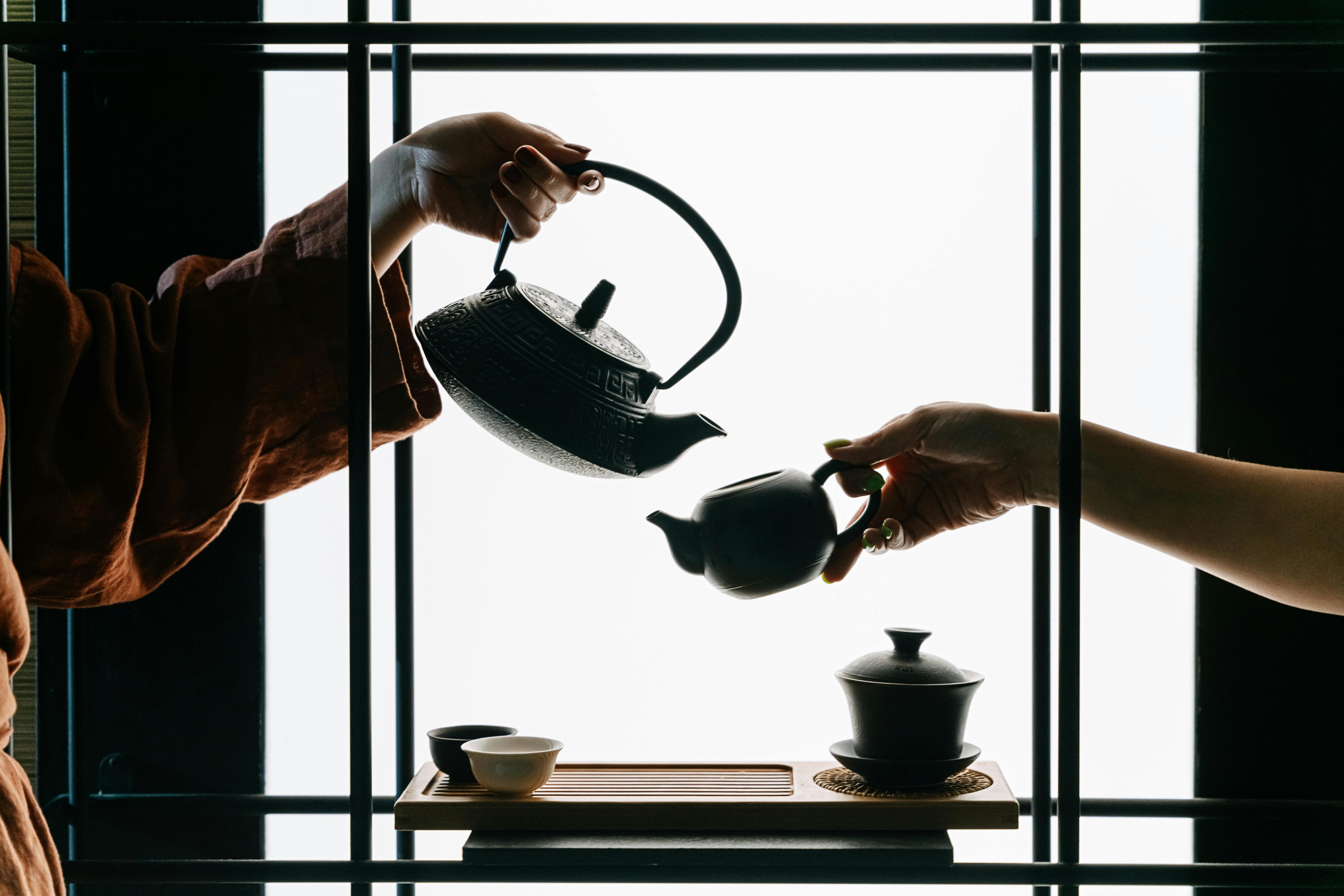 women hands holding teapots