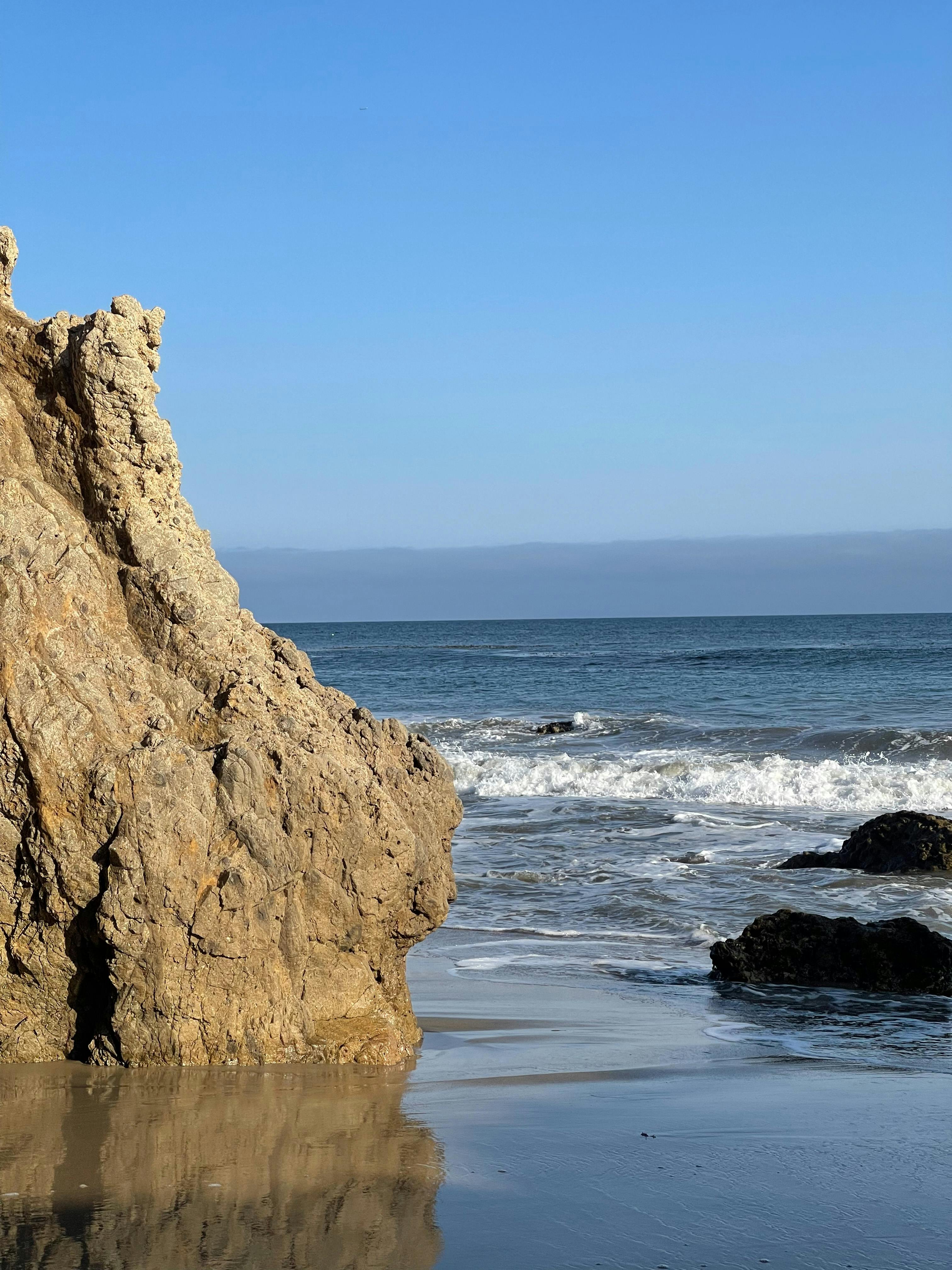 Waving sea splashing near stony shore · Free Stock Photo