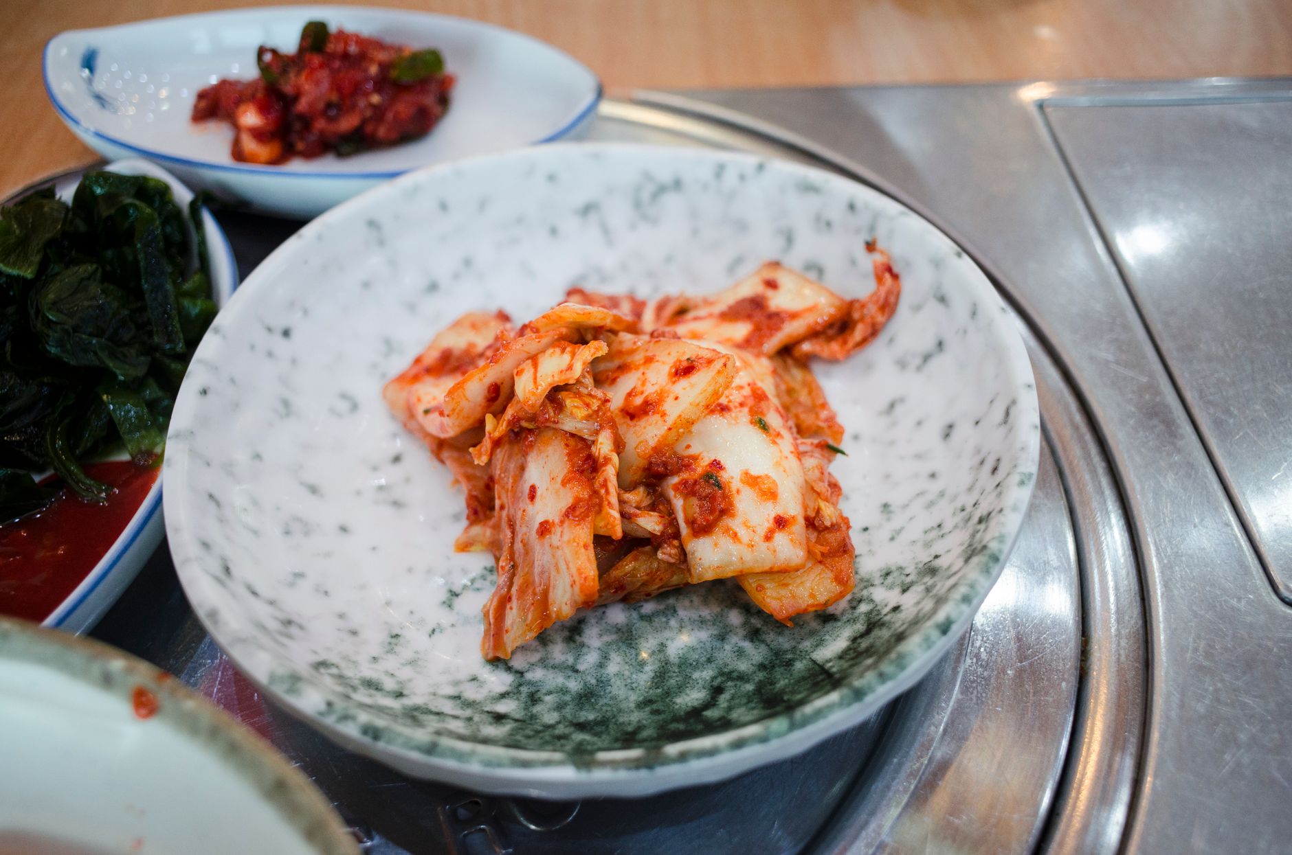 Jar of kimchi showing fresh and fermenting stages