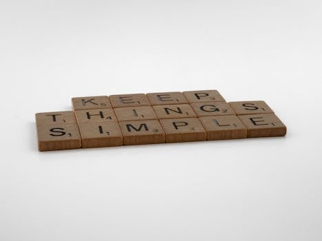 Inspirational 'Keep Things Simple' phrase using wooden Scrabble tiles on white background.