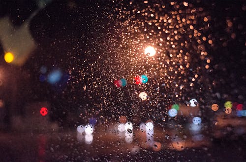Blurry City Lights From Behind a Rainy Window at Night 