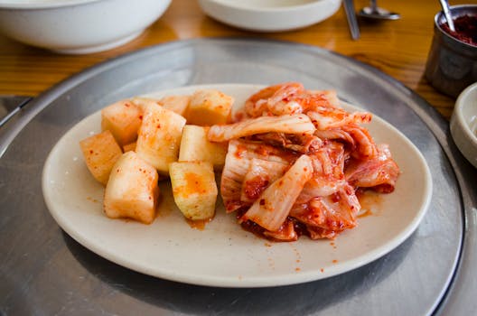 Close-up of traditional Korean kimchi and cubed radish on a plate, capturing vibrant colors and textures.