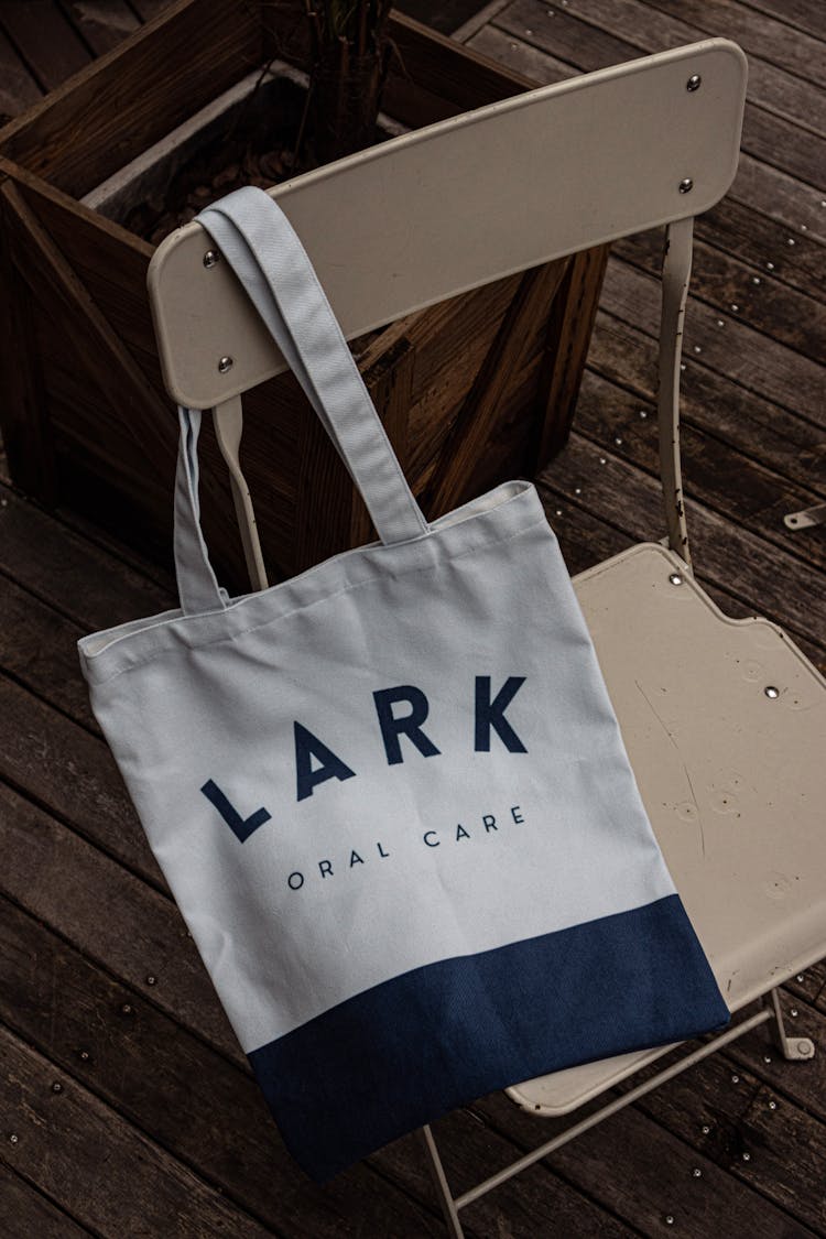 White And Blue Tote Bag With Logo On Chair