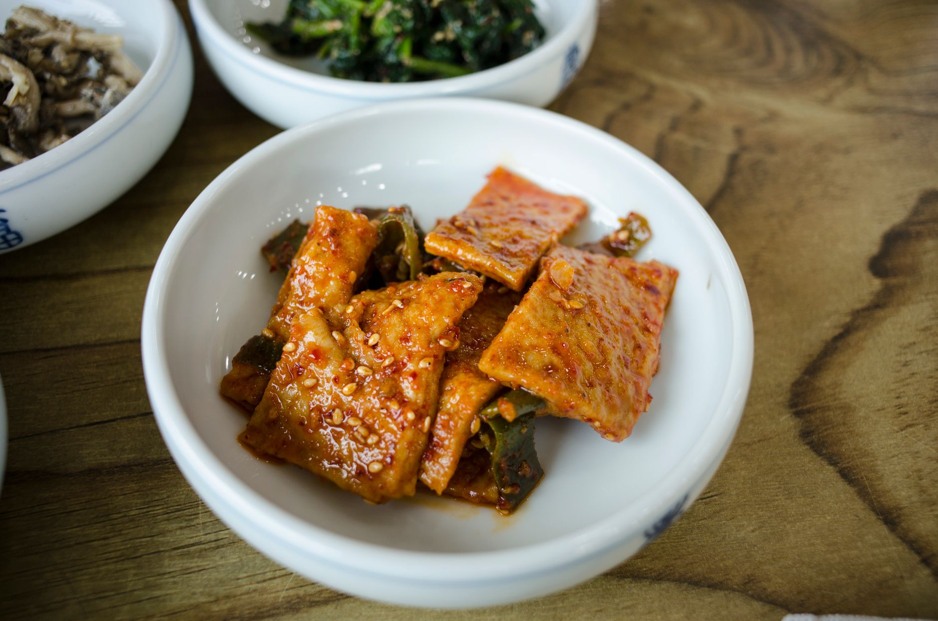 Close-up of a spicy Korean dish in a white bowl, showcasing vibrant colors and textures.