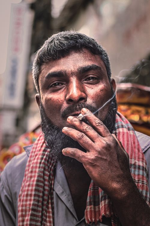 Free Close-up portrait of a South Asian man smoking in the streets of Dhaka, Bangladesh. Stock Photo