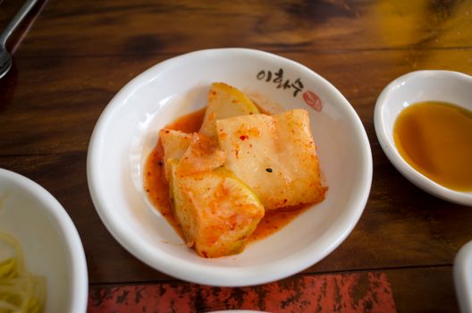 Close-up of Korean kkakdugi, diced radish kimchi, served as a side dish.