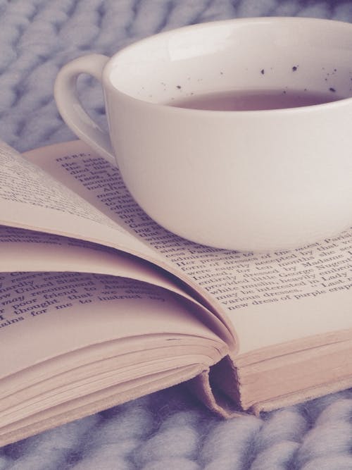 White Ceramic Cup on Top of Book