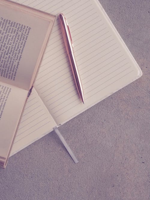 Free Book and Pen on Notebook Stock Photo