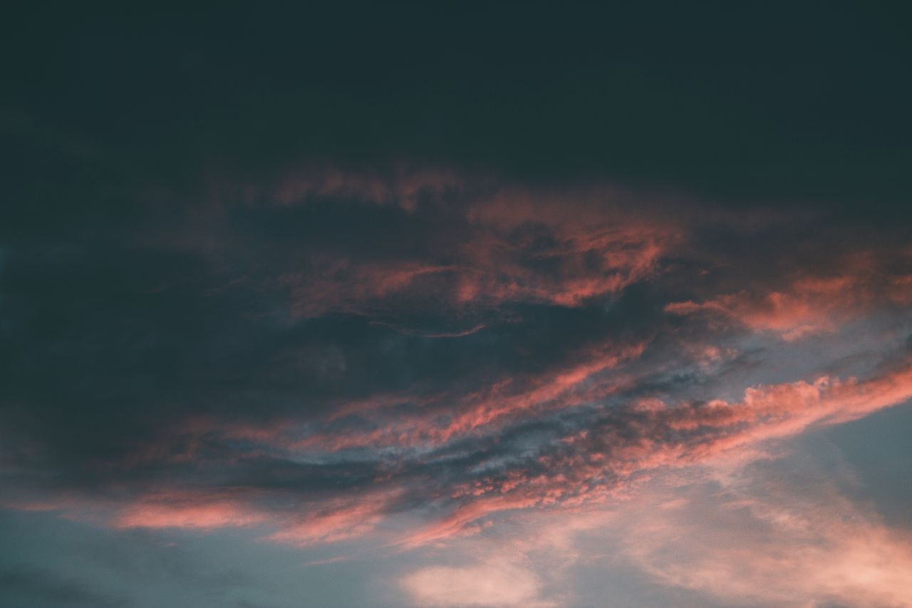 a captivating view of dramatic clouds painted with pink hues during su