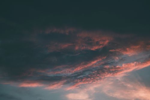 Free A captivating view of dramatic clouds painted with pink hues during sunset. Stock Photo