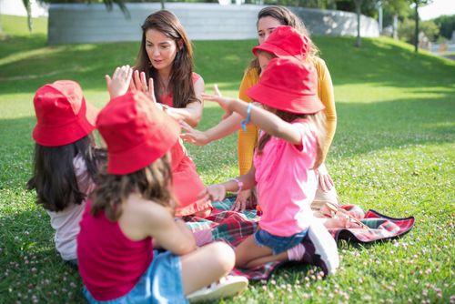 Free Children and adults enjoy a playful outdoor activity day in a scenic park. Stock Photo