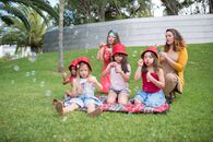 3 Girls Sitting on Green Grass Field