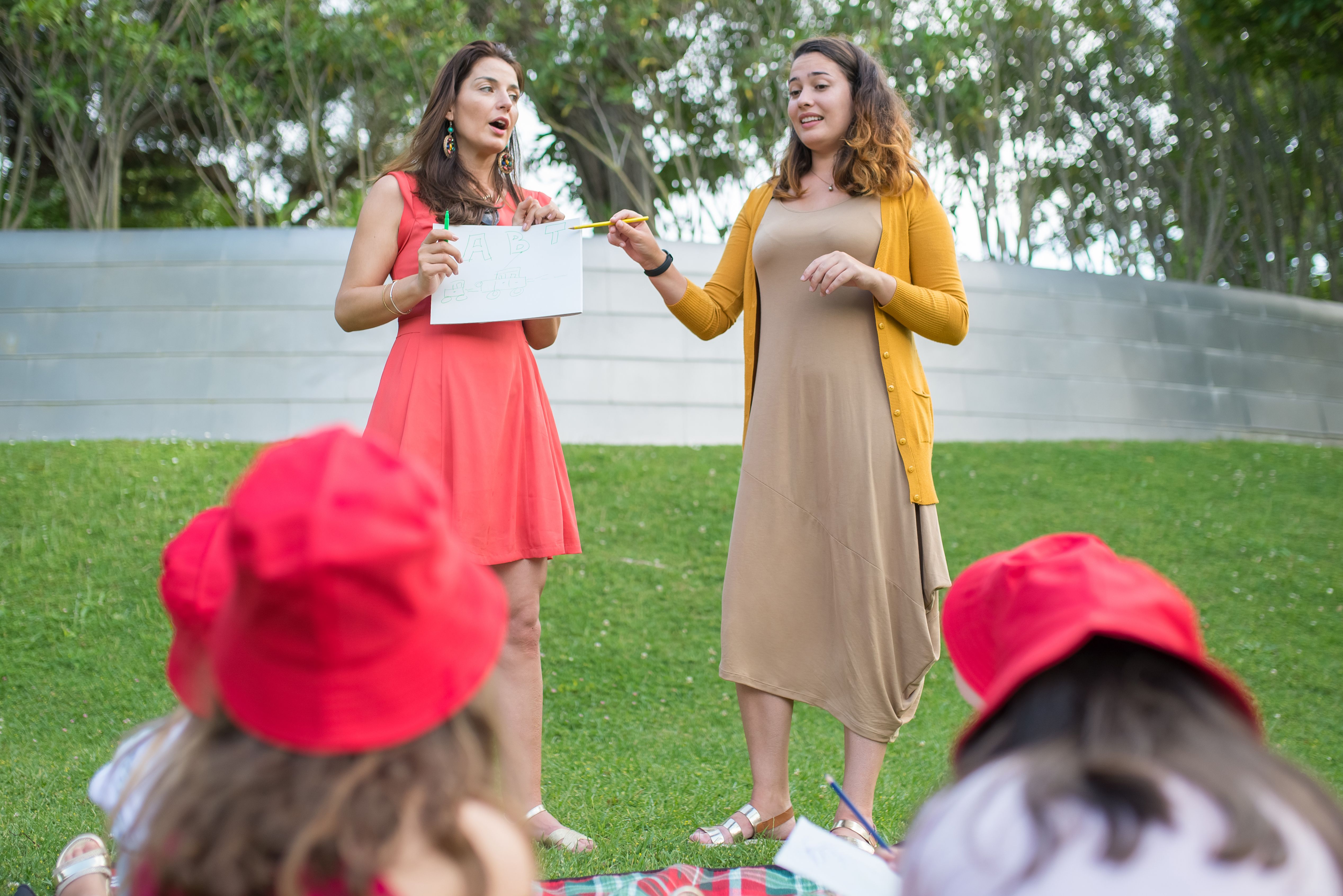 Women teaching a group of children outdoors in a park in Portugal.