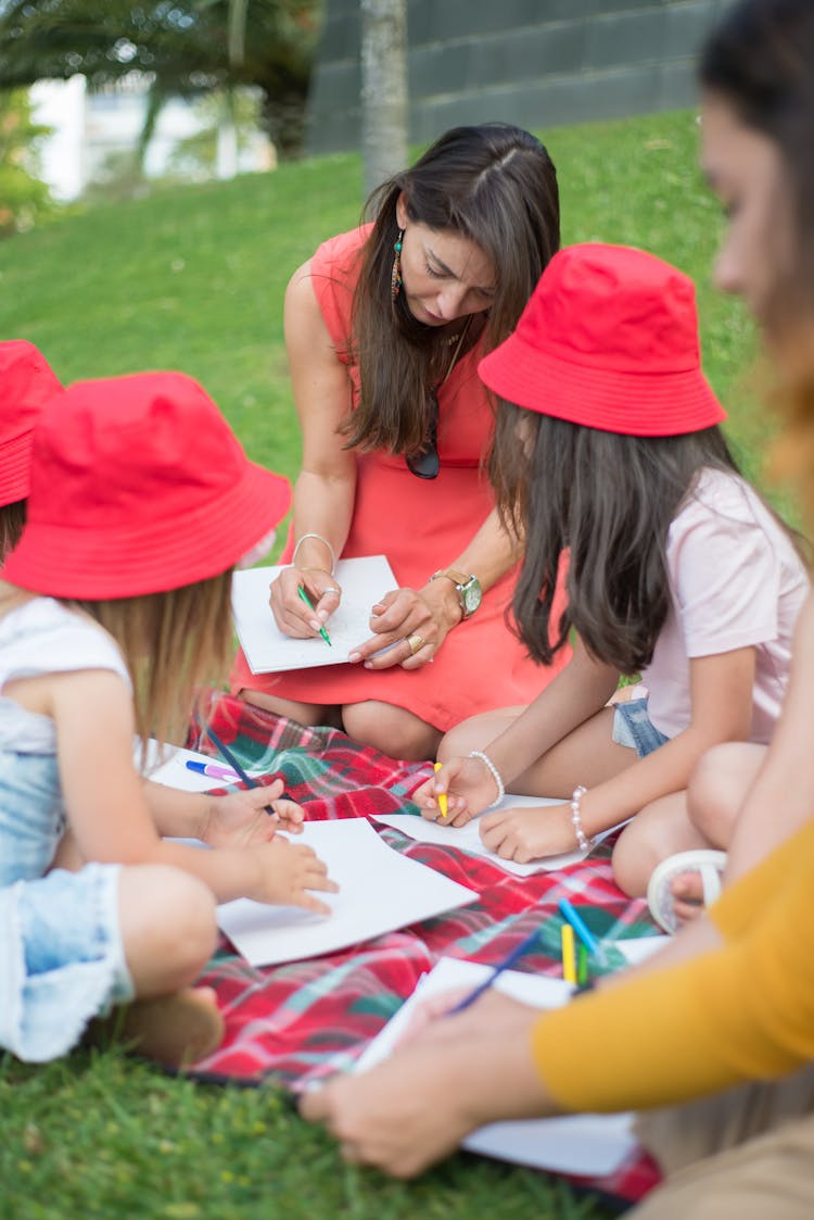 A Woman Drawing With Kids At A Park