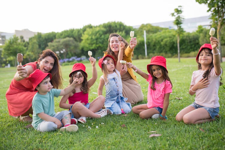 Close-Up Shot Of Mothers And Children Holding Ice Cream