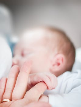 Tilt-shift Lens Photo of Infant's Hand Holding Index Finger of Adult