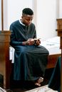Man Reading a Bible While Sitting on the Bed