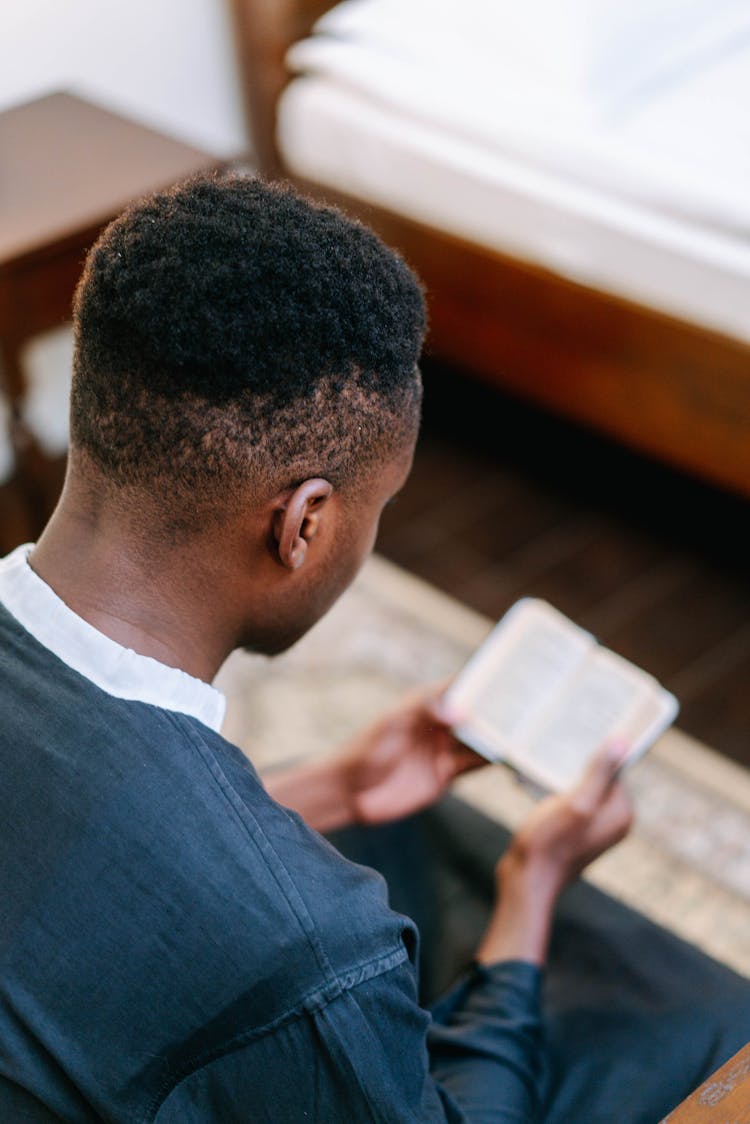 Person Reading A Small Bible 