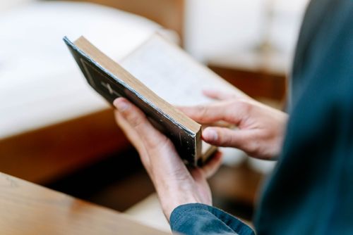 Free A person flipping through pages of a book in a serene indoor setting. Stock Photo