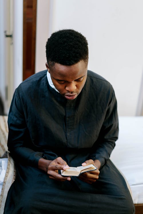 Free Man Wearing Soutane Reading a Bible Stock Photo