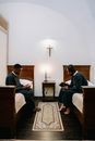 Men Wearing Soutanes Sitting on the Bed While Reading the Bible